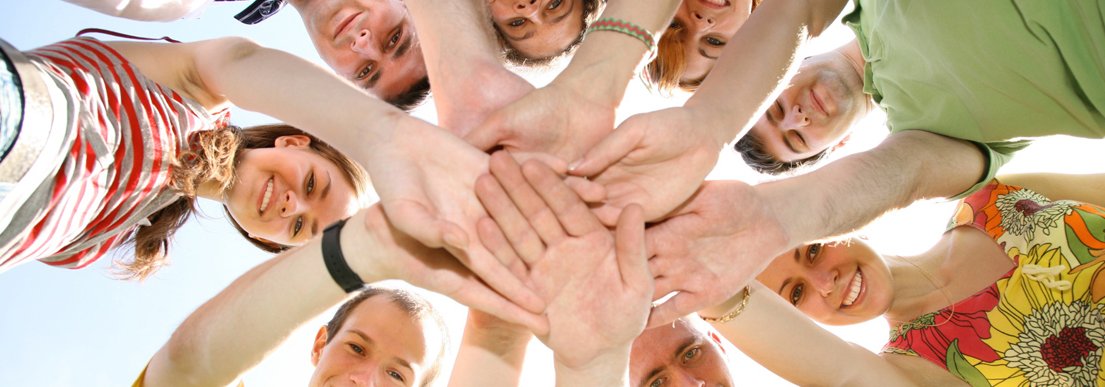 People in circle with hands on each other People in circle with hands on each other
