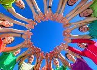 Gruppen von Menschen, die ihre Hände zu einem Kreis strecken