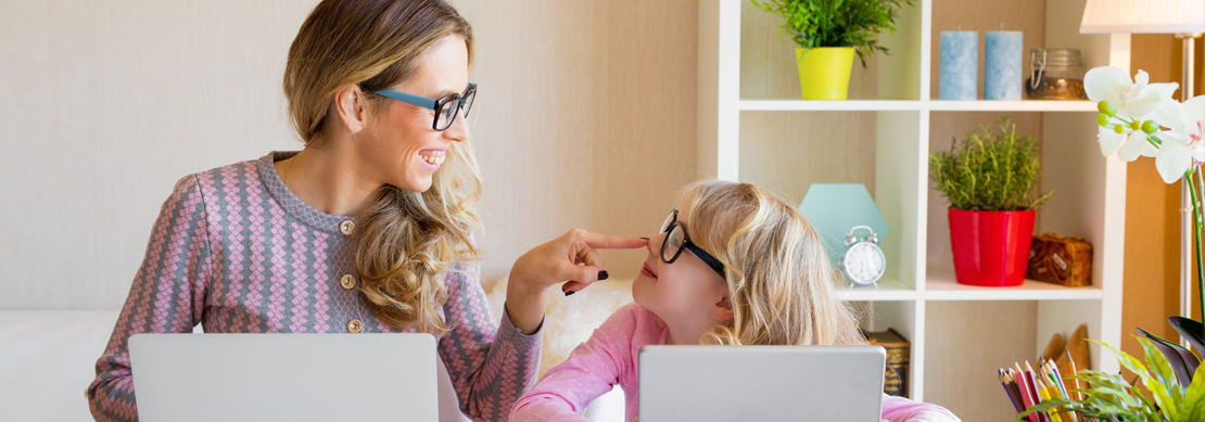 Woman and child in front of laptops